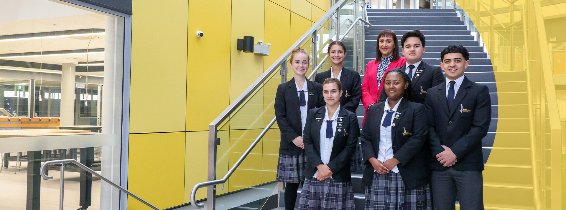 Students standing with principal Jeanette Holland on the stairs at St Agnes Catholic High School Rooty Hill