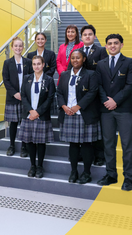 Students standing with principal Jeanette Holland on the stairs at St Agnes Catholic High School Rooty Hill