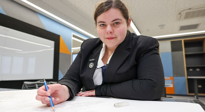 Student working on a project at the desk in the classroom at St Agnes Catholic High School Rooty Hill