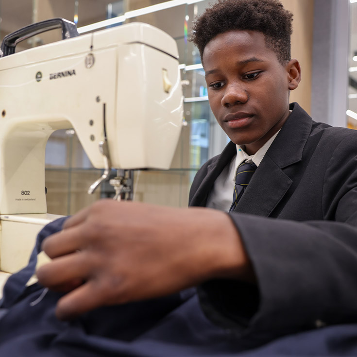 Student using the sewing machine in the classroom at St Agnes Catholic High School Rooty Hill