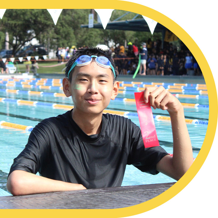 Student holding a race ribbon after his swimming race at St Agnes Catholic High School Rooty Hill
