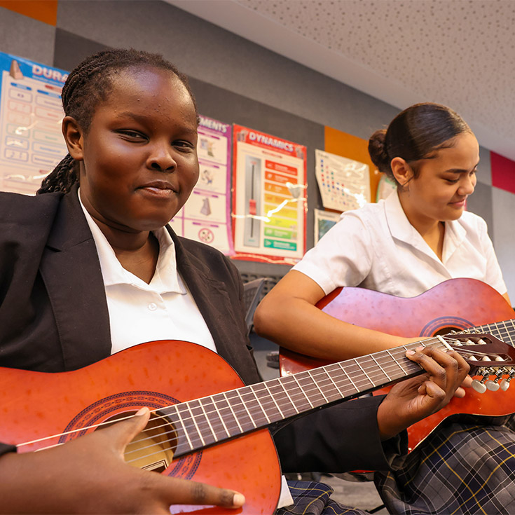 Two St Agnes Rooty Hill students playing guitar